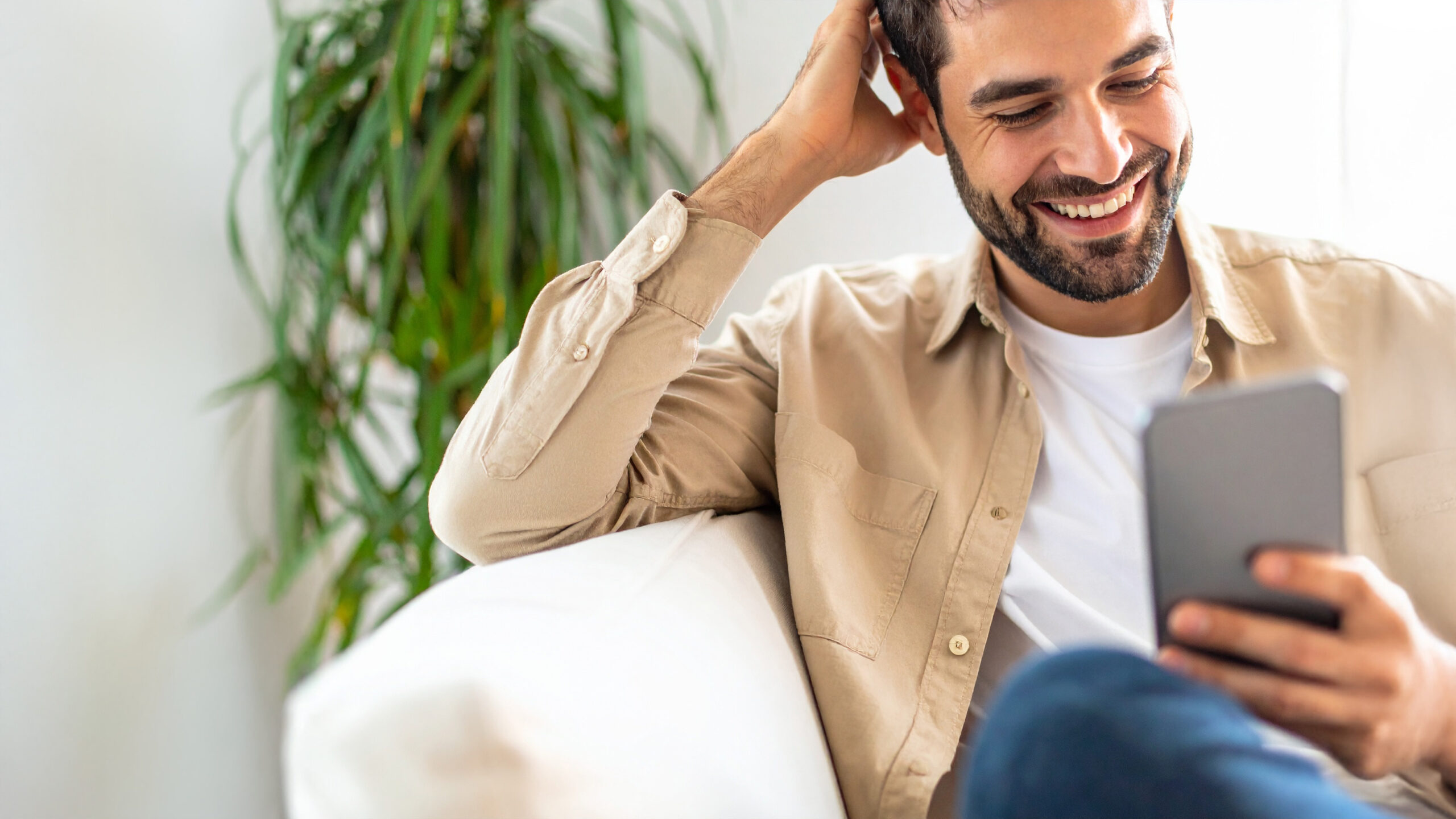 XTA - Imatge pel bàner mòbil - Home al sofà mirant el telèfon